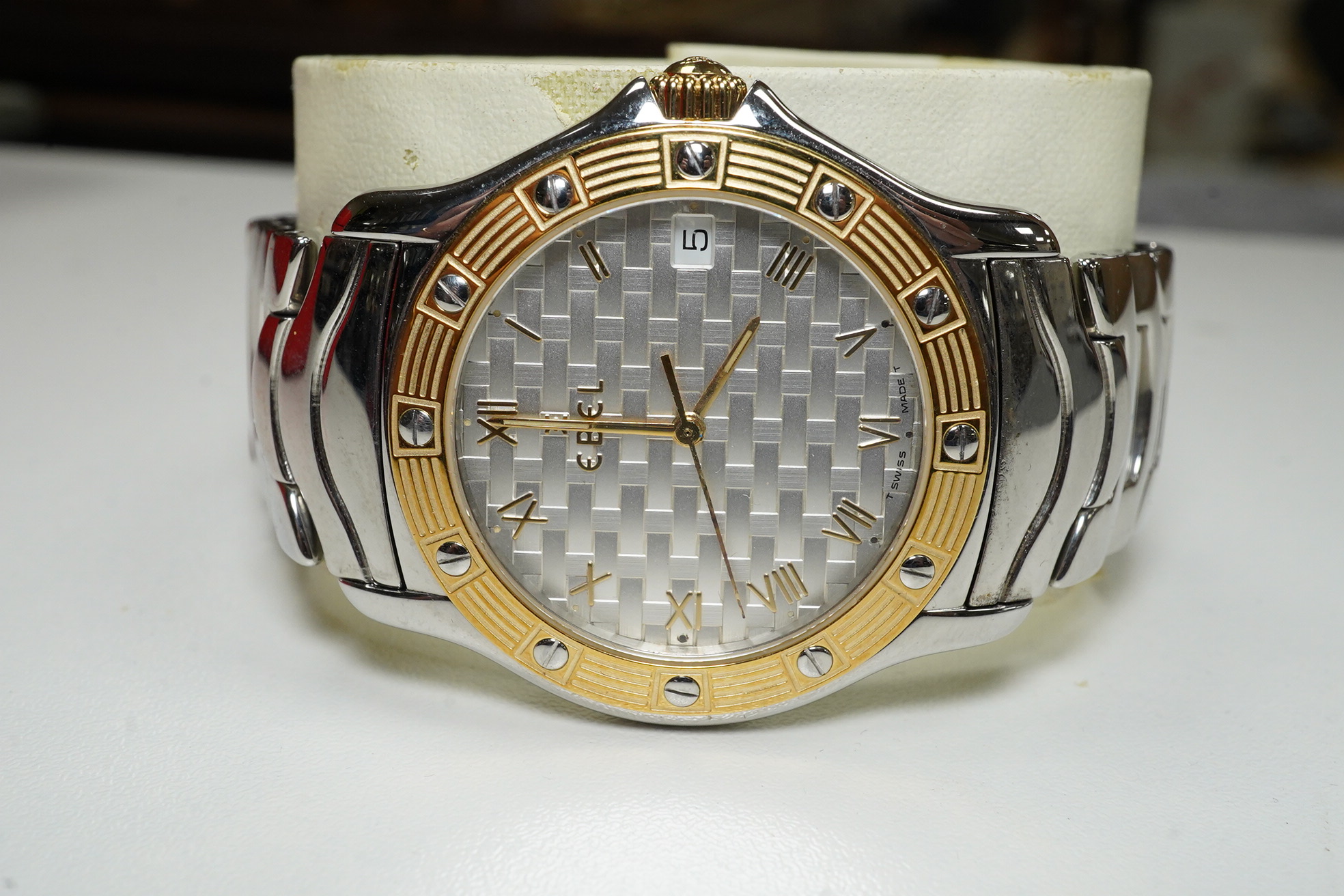 A gentleman's modern steel and gold plated Ebel Wave quartz wrist watch, with basket weave dial, on a stainless steel Ebel bracelet, with box. Condition - fair